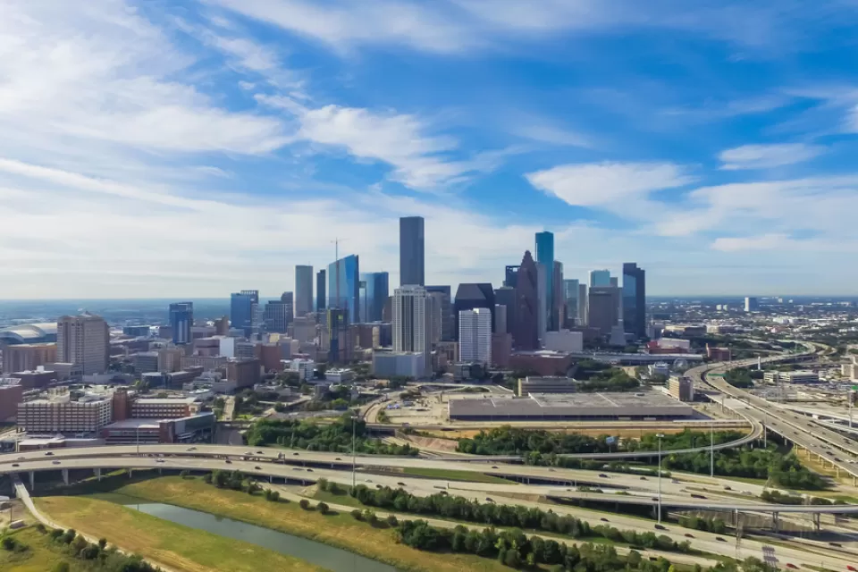 Serial view of elevated freeway interchanges with downtown Houston in background